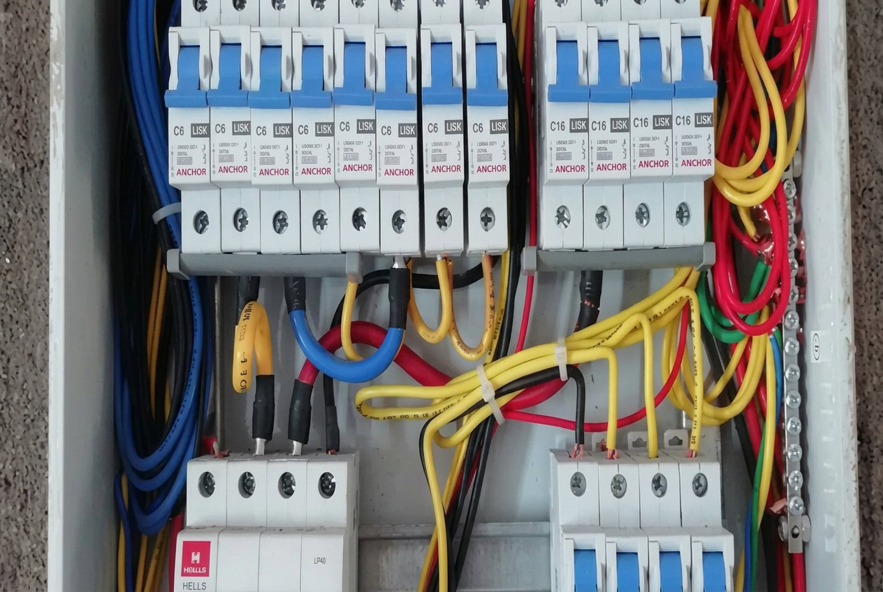 Distribution board with circuit breakers and colour-coded wiring installed in a building