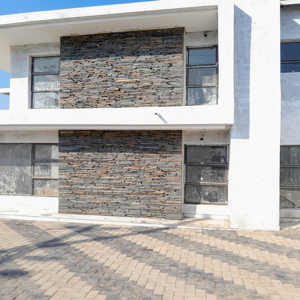 Paved driveway in front of a modern home with stone-clad facade